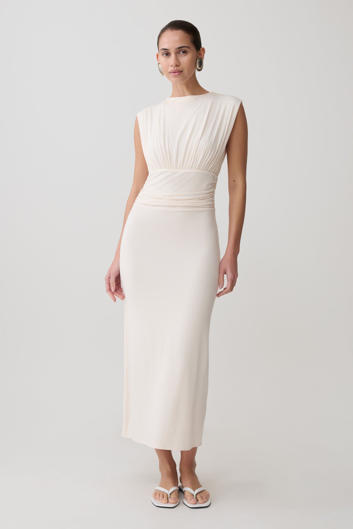 Woman wearing a white ruched modal sleeveless midi dress.
