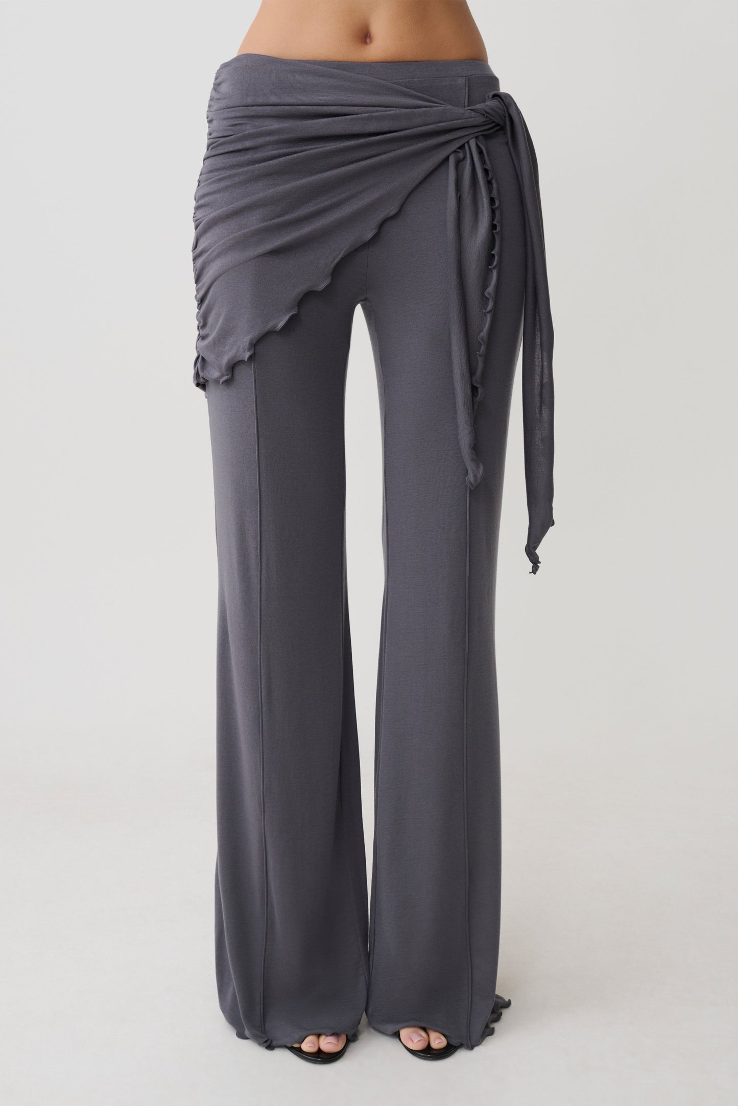 Woman wearing straight leg pants with waist wrap.