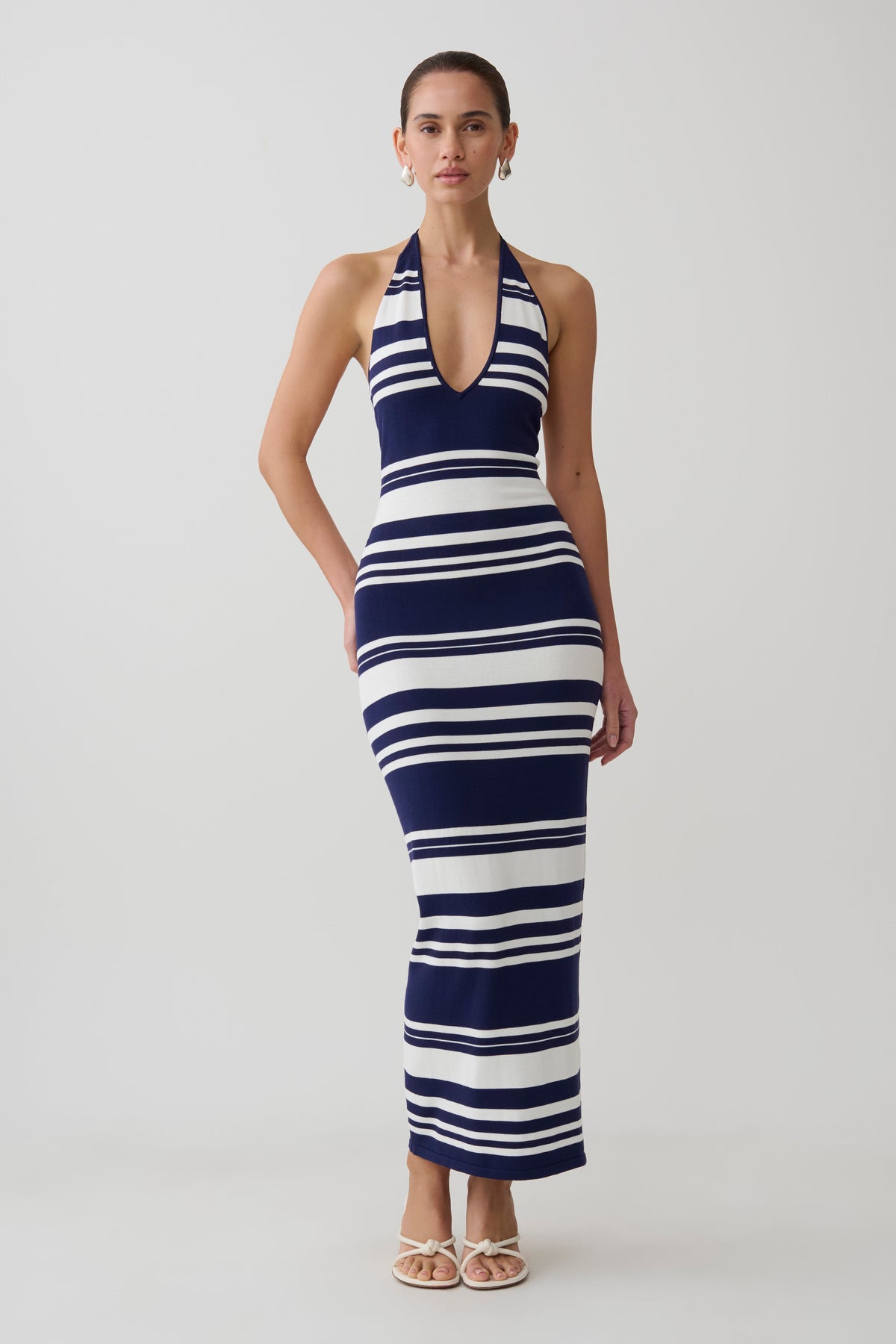 Woman wearing a navy and white striped maxi dress.