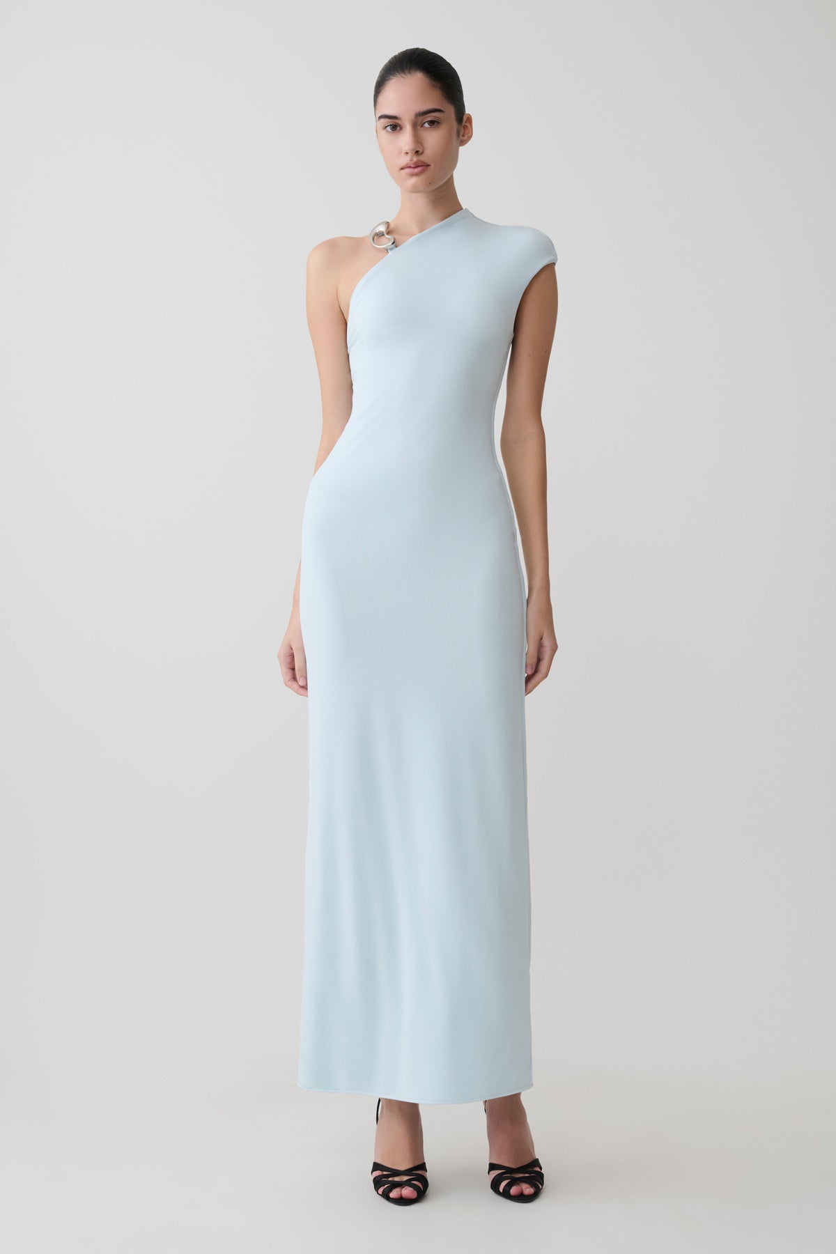Woman wearing a light blue slinky axi dress with hardware.