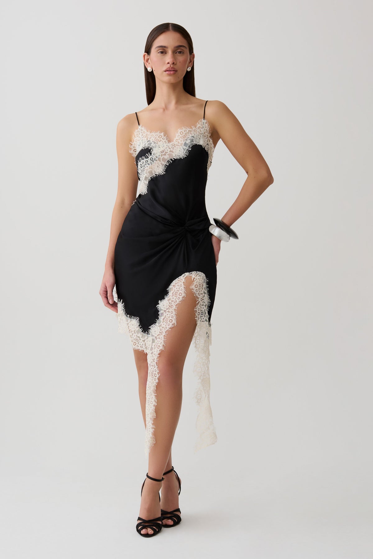 Woman wearing a black and white satin and lace mini dress.