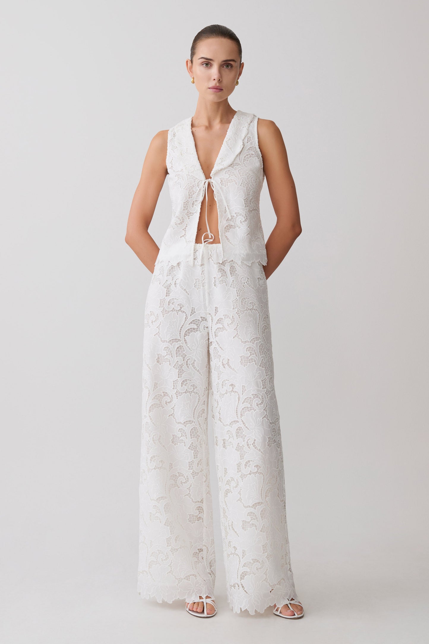 Woman wearing a white broderie tie top with matching pants.