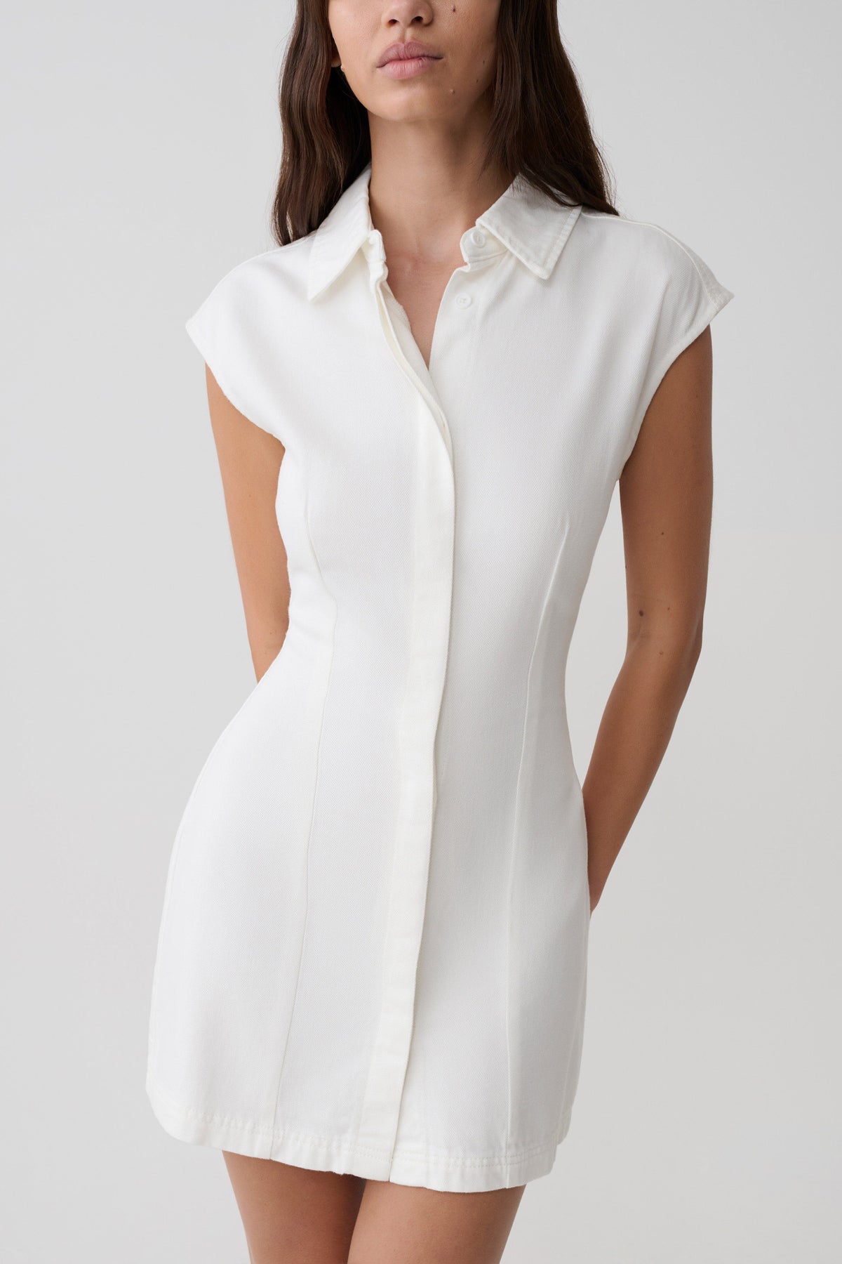 Woman wearing a white collared mini denim dress.