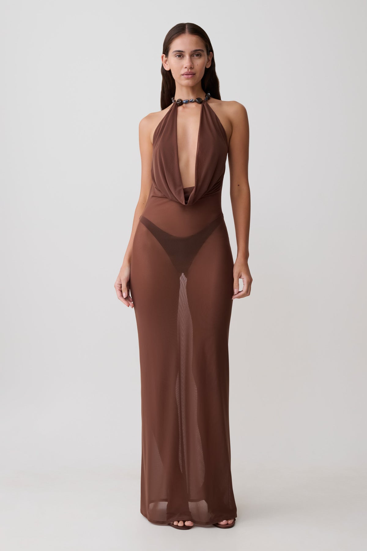 Woman wearing a brown mesh cowl plunge maxi dress.