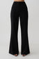 Woman wearing black high waisted suiting pants.