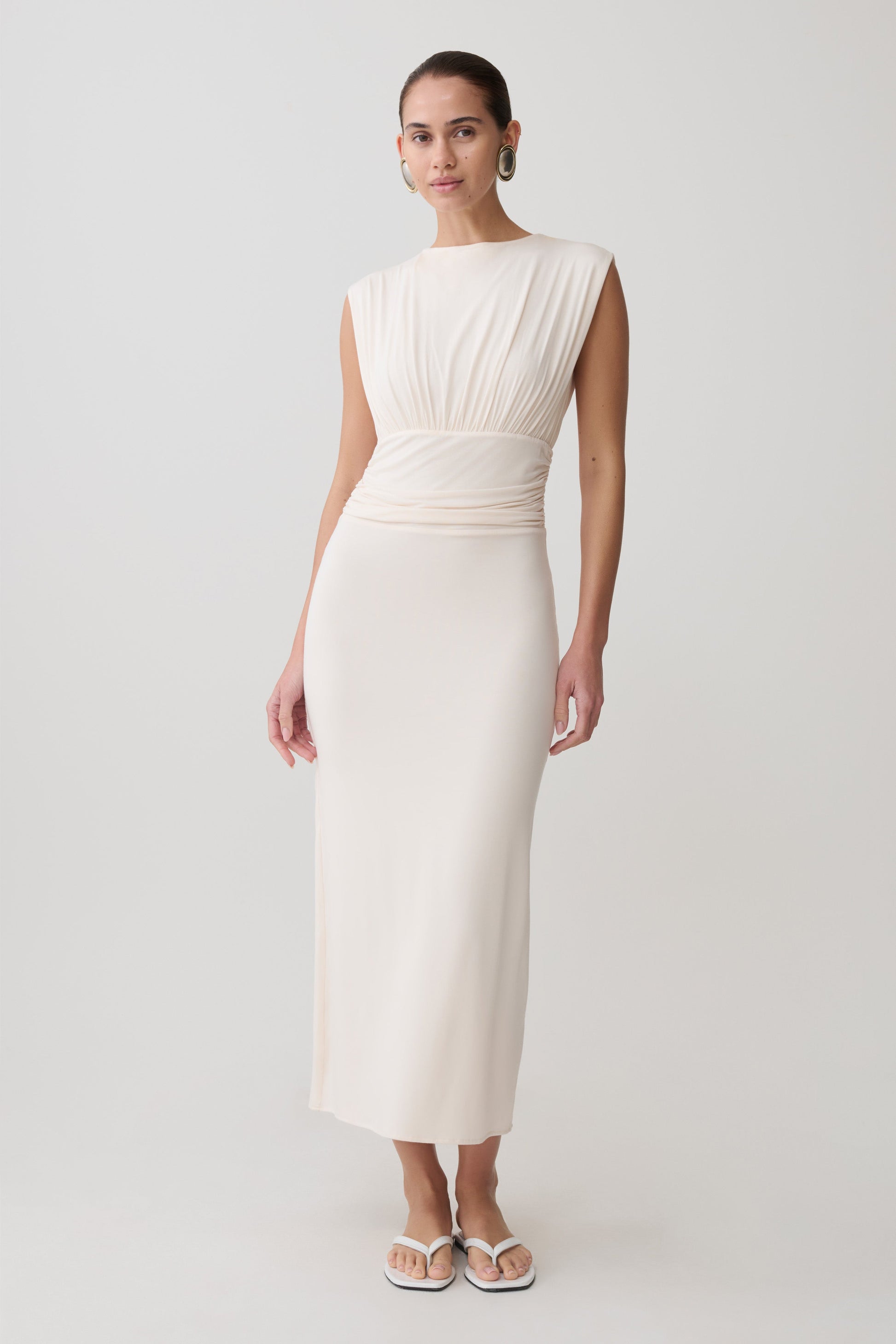 Woman wearing a white ruched modal sleeveless midi dress.