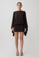 Woman wearing a dark brown draped mini dress.
