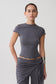 Woman wearing a grey high neck top with piping detail.