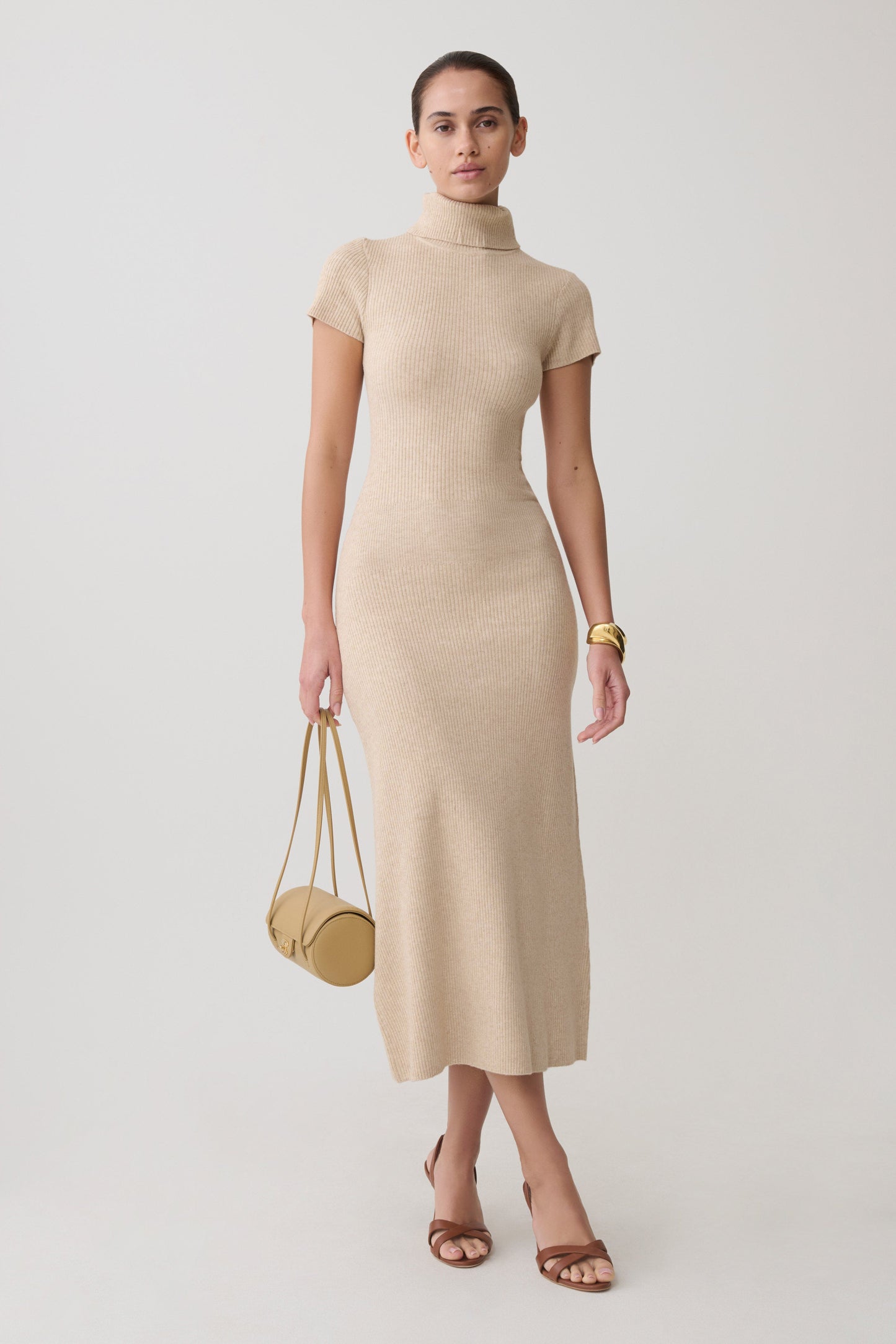 Woman wearing a beige high neck knit midi dress.