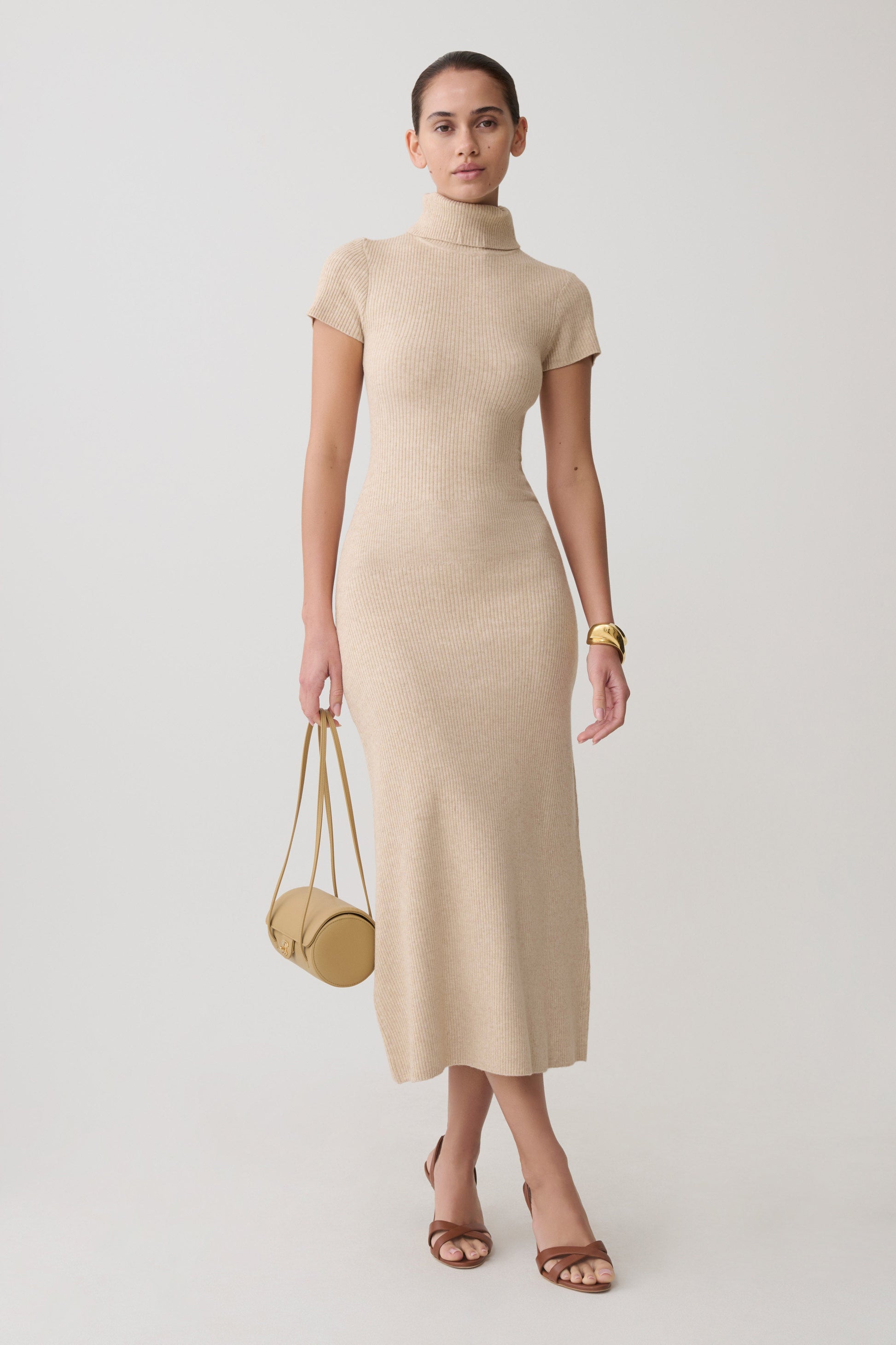 Woman wearing a beige high neck knit midi dress.