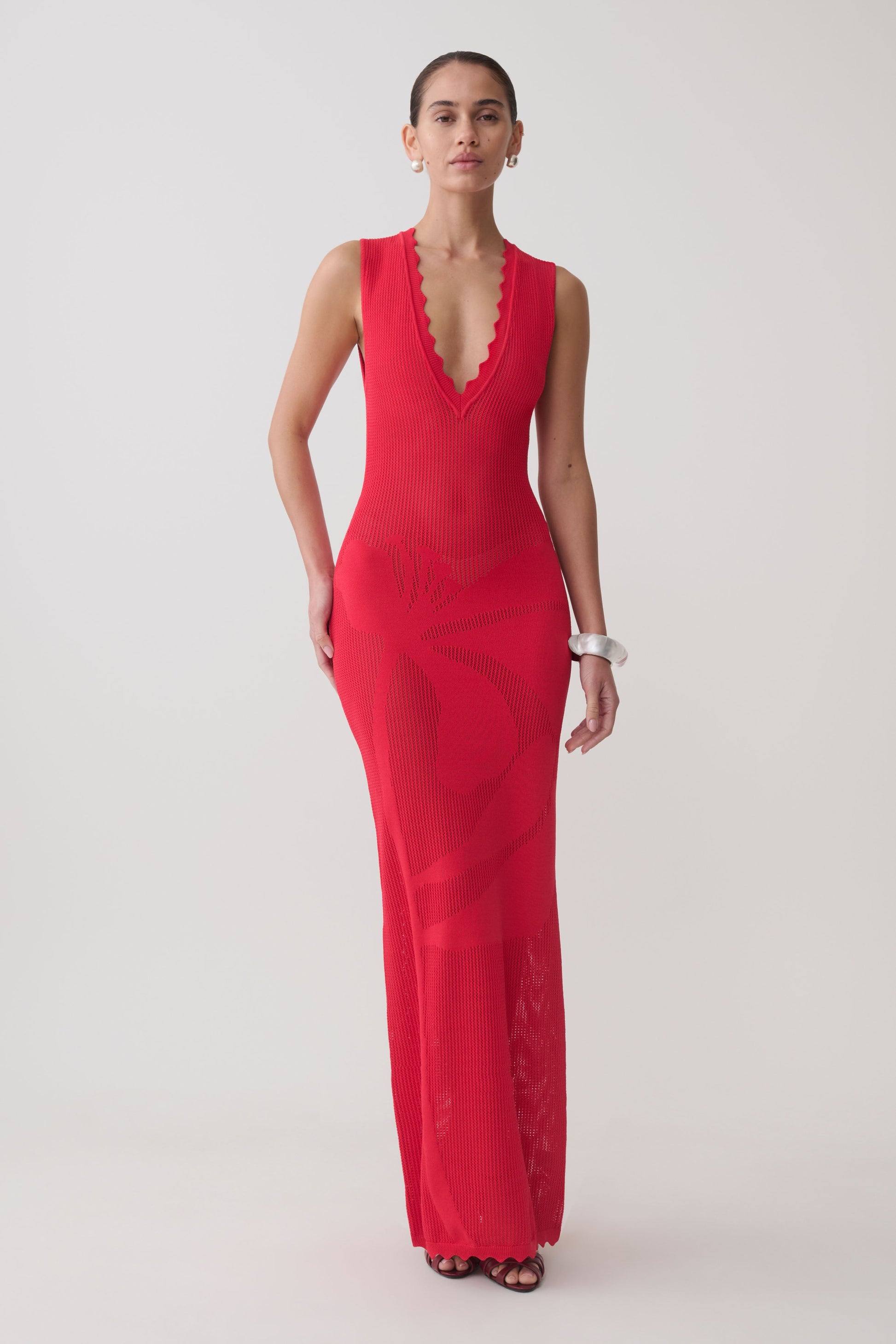 Woman wearing a red floral knit maxi dress.