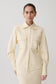 Woman wearing white faux leather shirt.