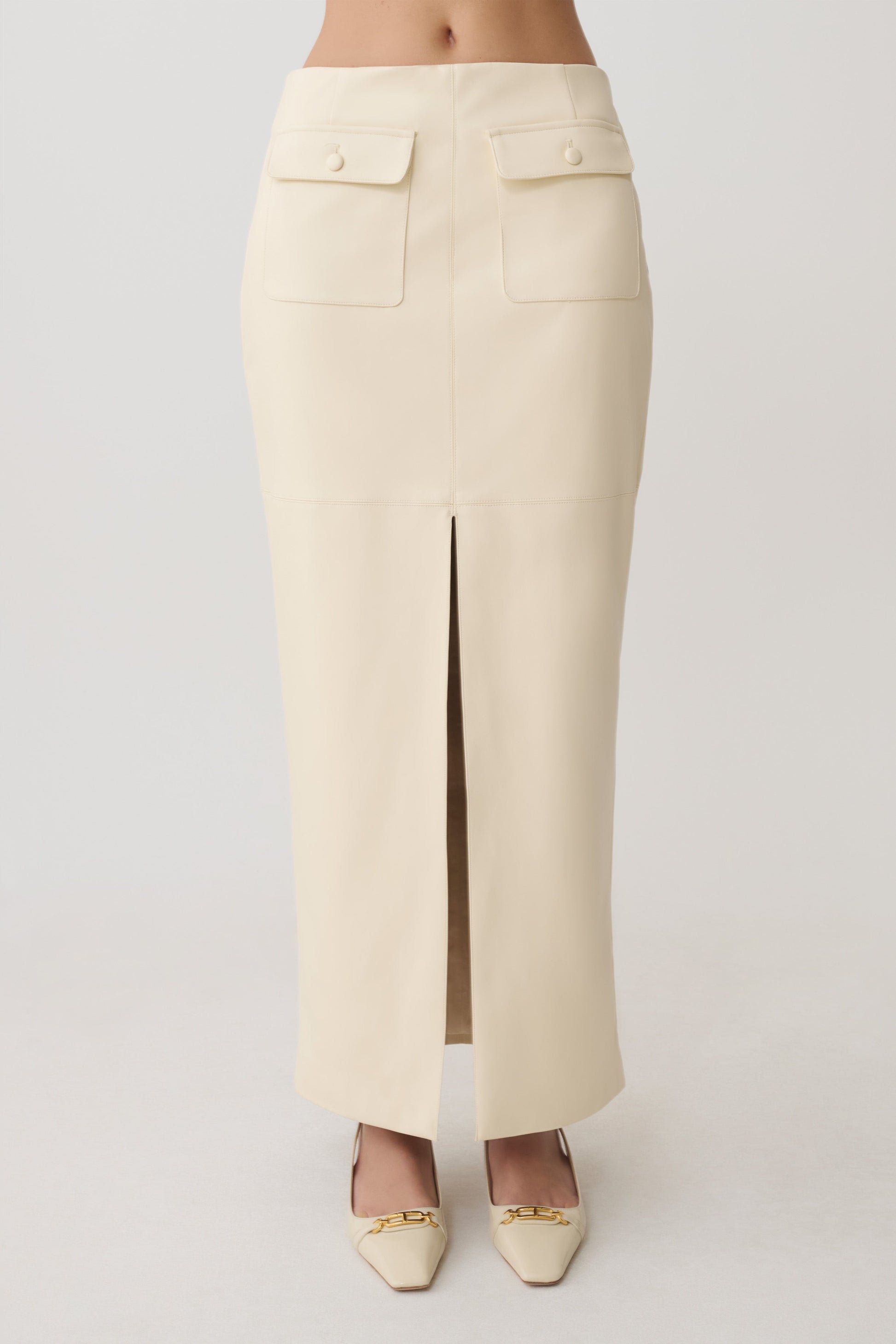 Woman wearing a white faux leather maxi skirt.