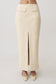 Woman wearing a white faux leather maxi skirt.