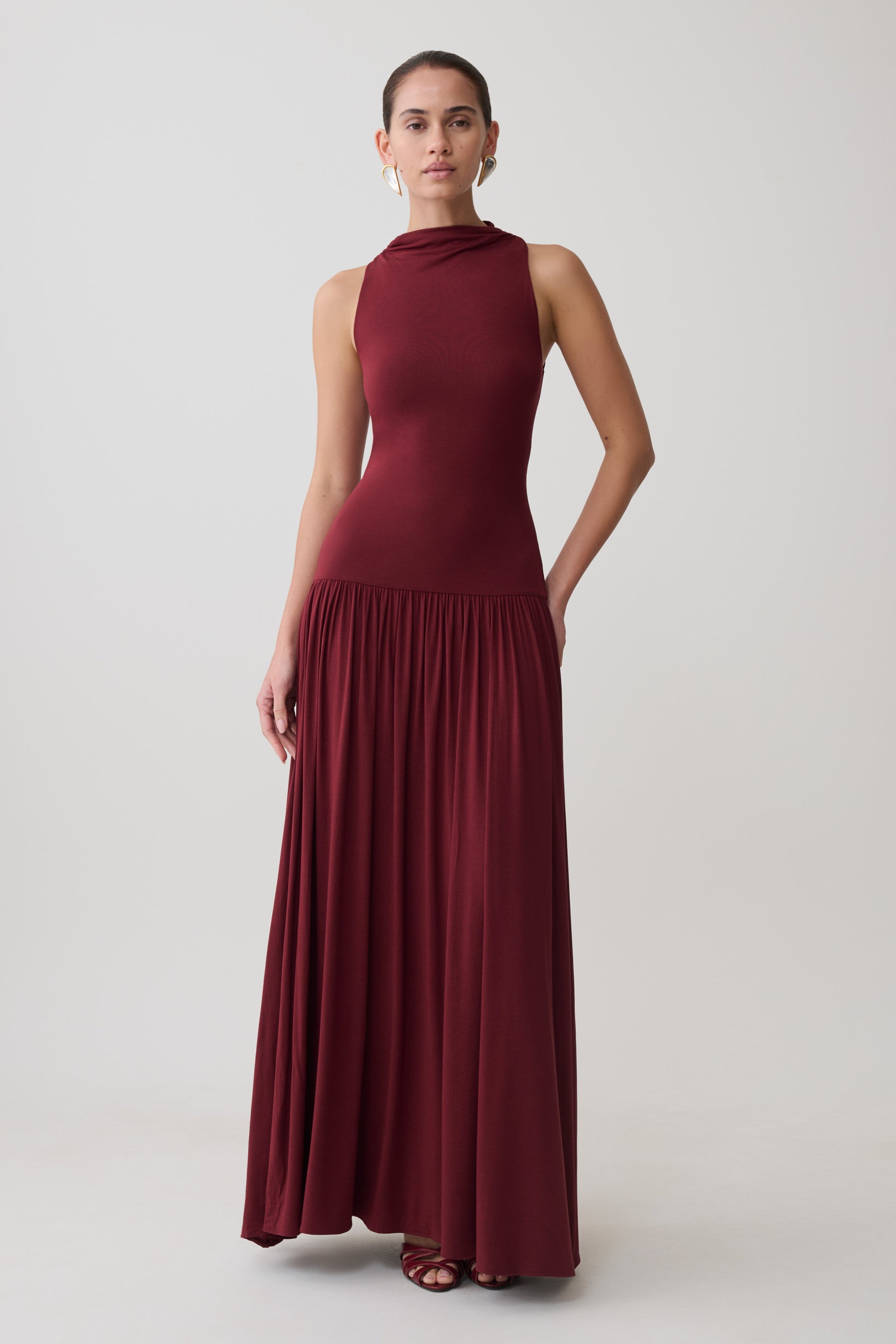 Woman wearing a dark red high neck modal maxi dress.