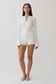 Woman wearing a white pointelle knit long sleeve top with matching shorts.