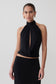 Woman wearing a black sleeveless halter top.