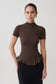 Woman wearing a brown short sleeve ruffle top.