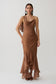 Woman wearing a brown draped maxi dress.