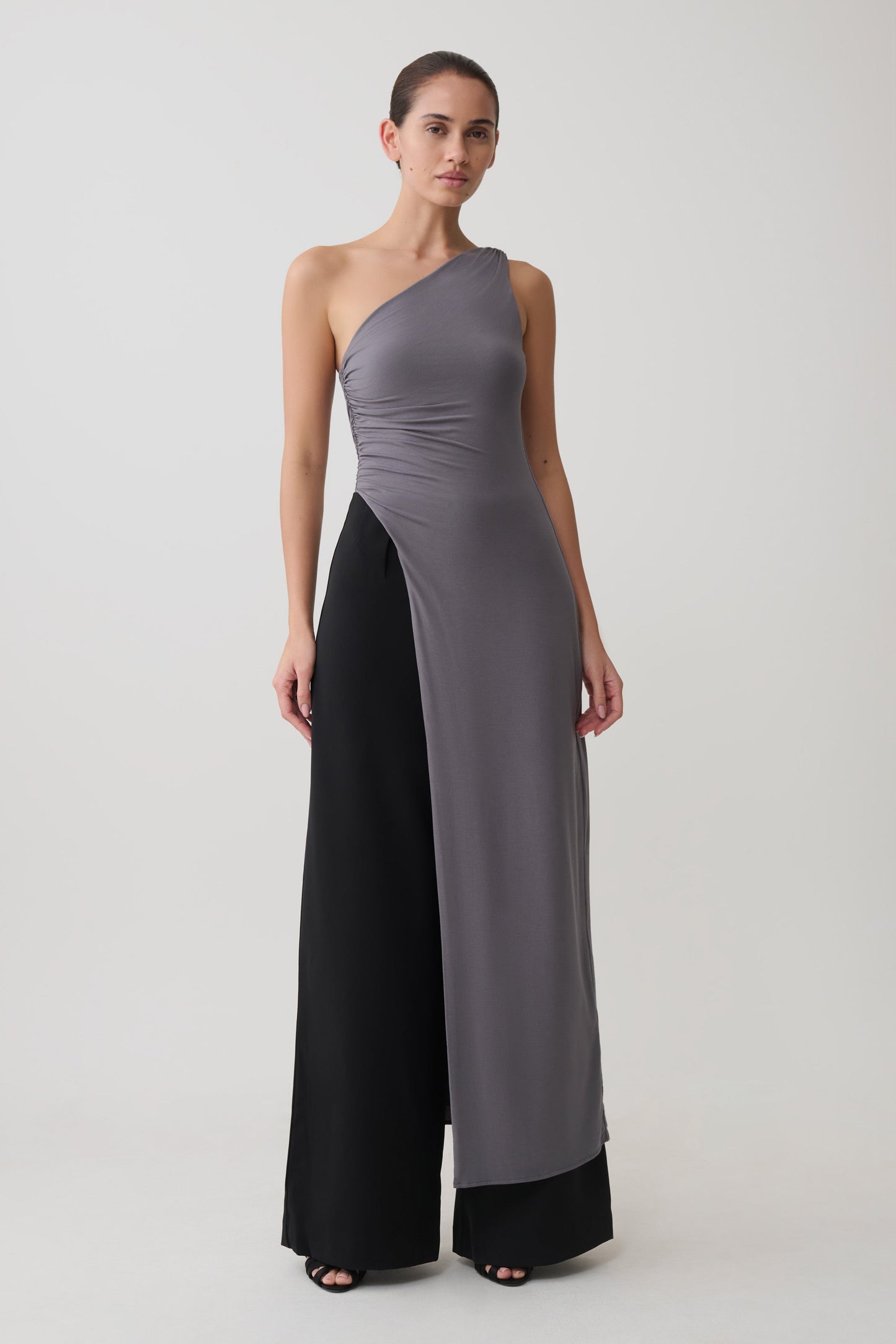 Woman wearing a grey long line top with front cut out.