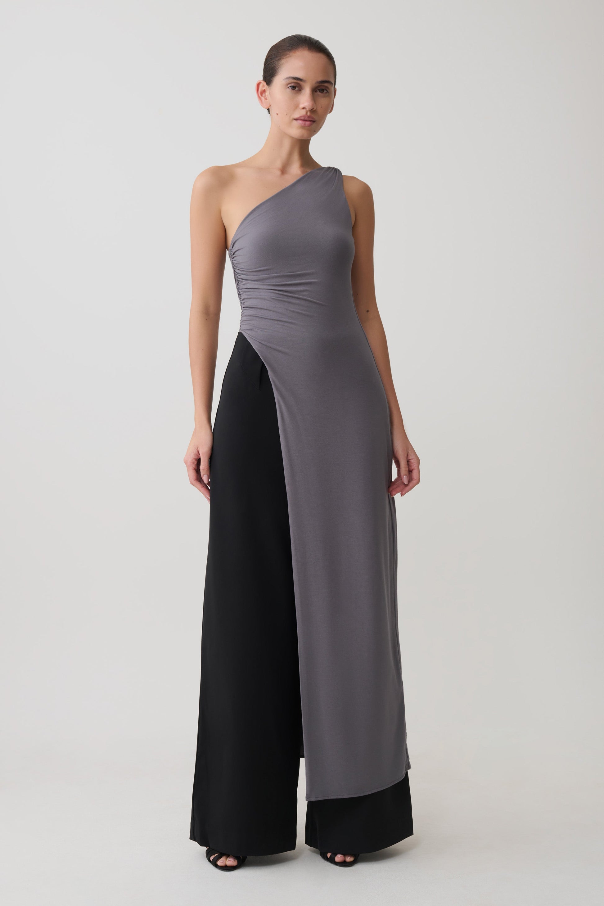 Woman wearing a grey long line top with front cut out.