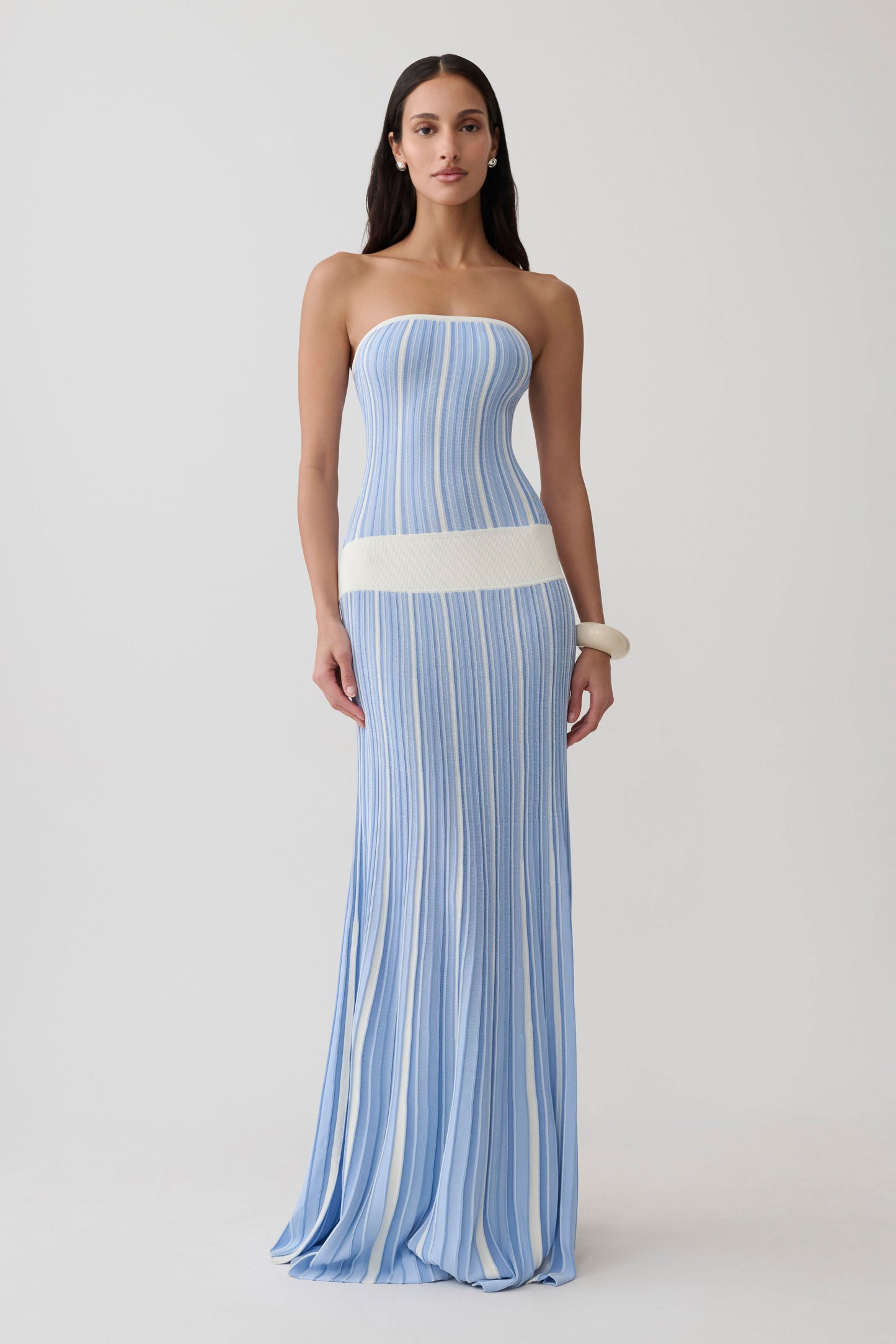 Woman wearing a blue and white striped maxi knit dress.