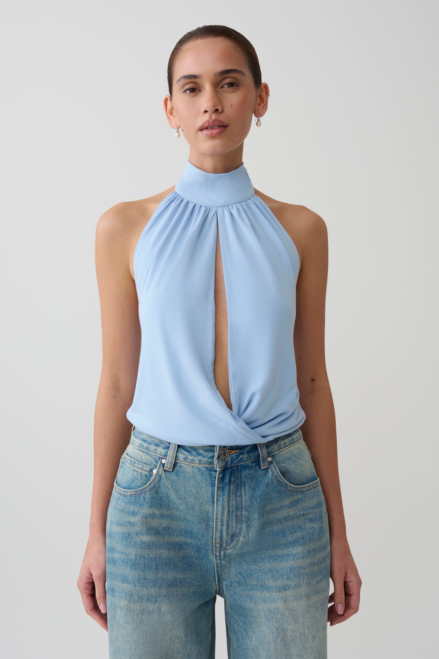 Woman wearing a blue viscose sleeveless halter top.