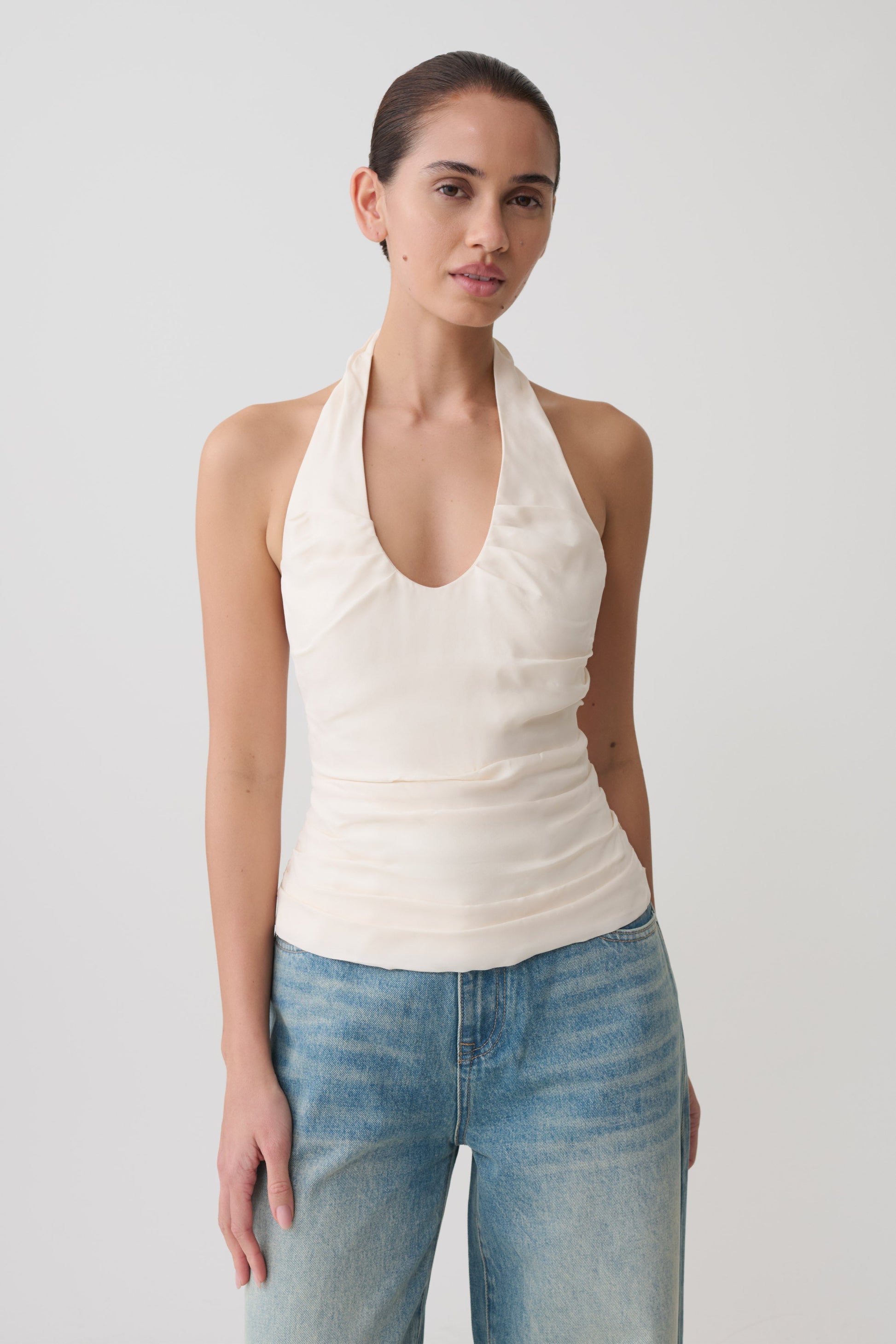 Woman wearing a white ruched halter top.