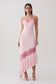 Woman wearing a pink frilled hem lace midi dress.