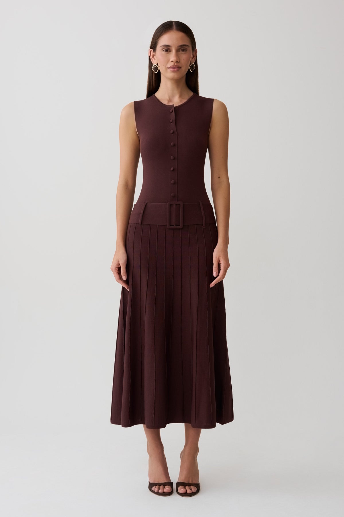 Woman wearing a brown pleated midi dress.