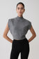 Woman wearing a gray sleeveless knit top against a plain background.