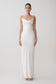 Woman wearing a white slip dress on a plain background