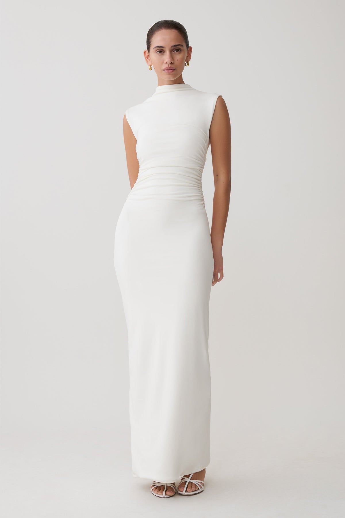 Woman wearing a white dress against a plain background