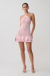 Woman wearing a pink crochet dress on a white background