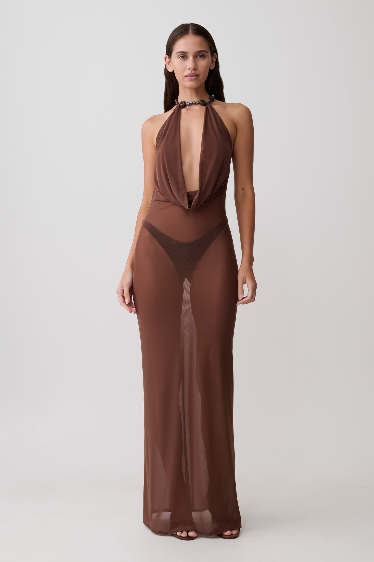 Woman wearing a brown mesh cowl plunge maxi dress.