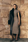 Woman wearing a grey high neck knit midi dress.