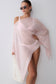 Woman wearing a pink sheer draped asymmetric top.